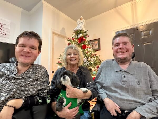 Mom, Blake, Pepper the dog, and I in front of our Christmas tree.